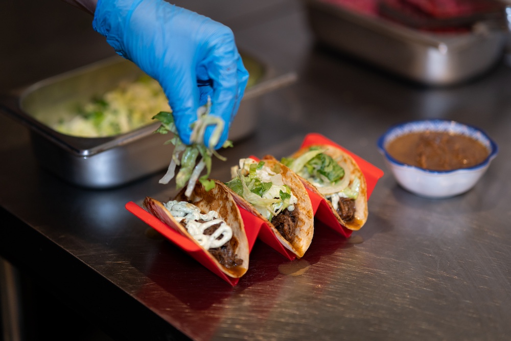 garnishing birria tacos