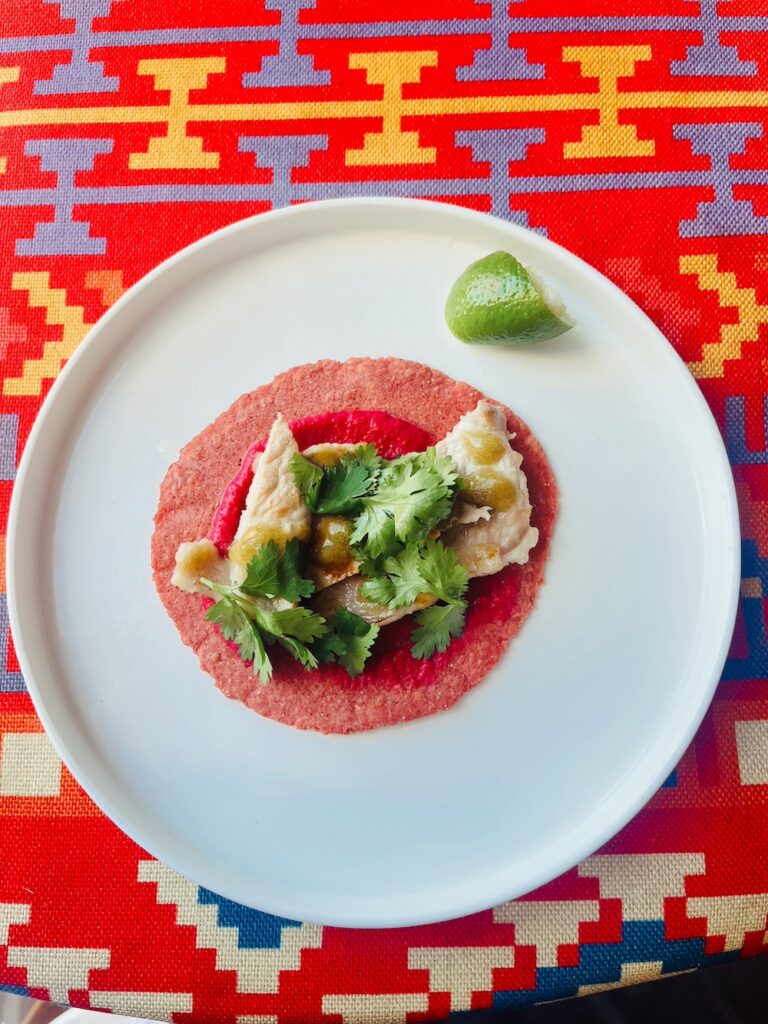 pork ribeye taco on a beetroot-infused corn tortilla and tkemali-jalapeno salsa