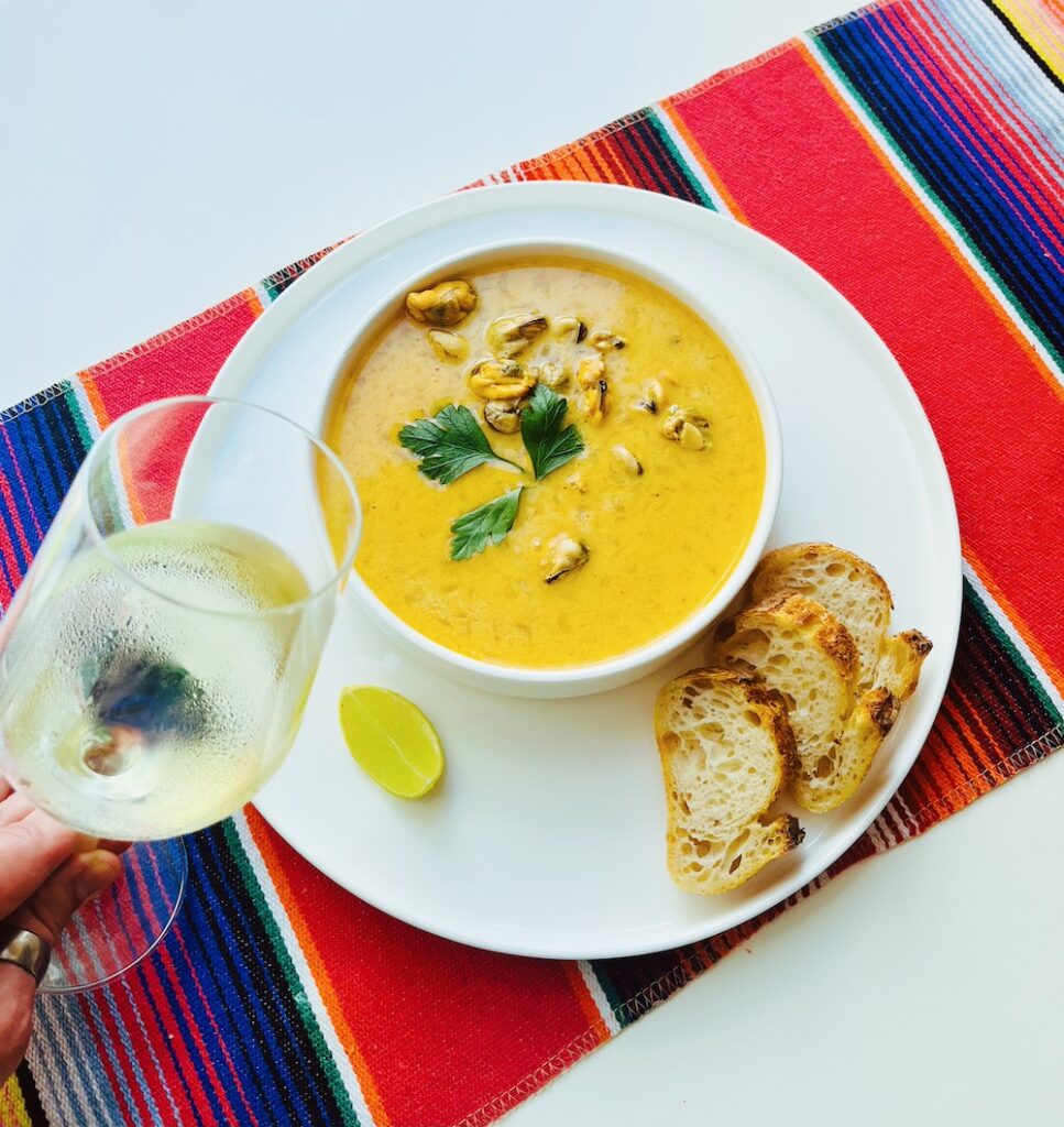 mussels in white wine sauce and chipotle crema with a glass of wine
